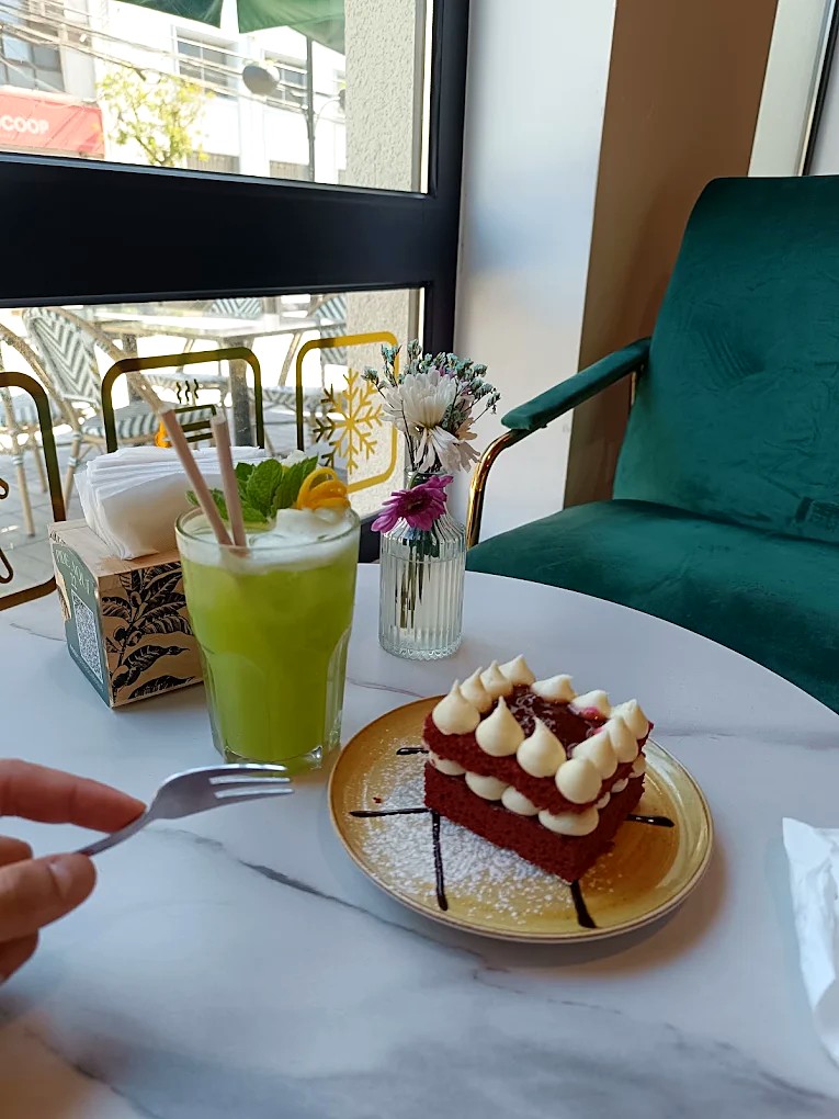 Torta red velvet y jugo verde en una mesa de Café Baqué del Teatro