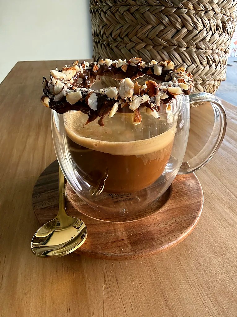 Café con borde de chocolate y avellanas en Café Baqué del Teatro